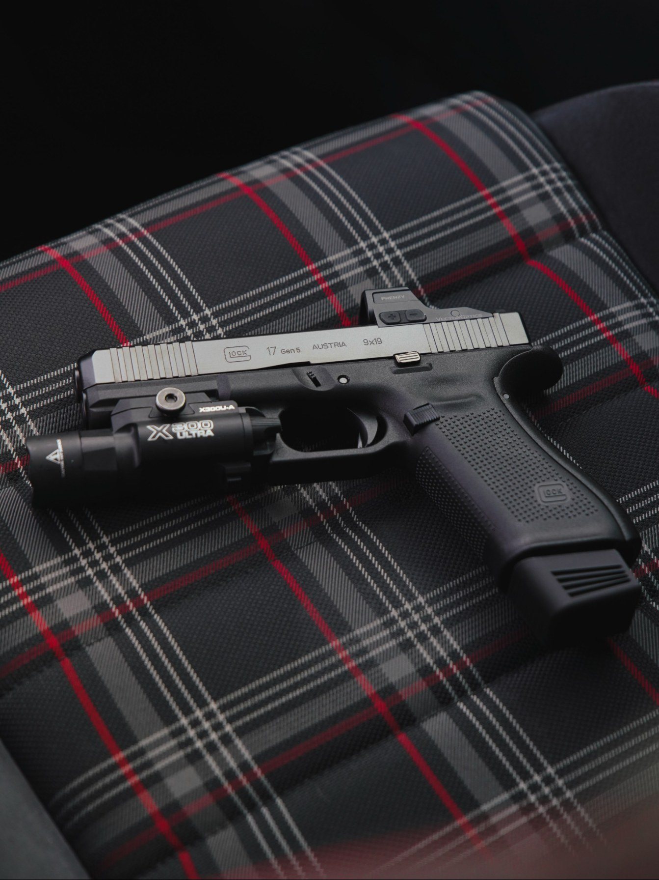 Glock 17 Gen5 équipé d'un point rouge Vector Optics Frenzy et d'une lampe, posé sur un tissu écossais